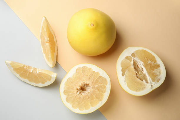 Ripe pomelo fruit on two tone background, top view