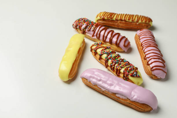 istock Tasty eclairs with different topping on white background 1296988006