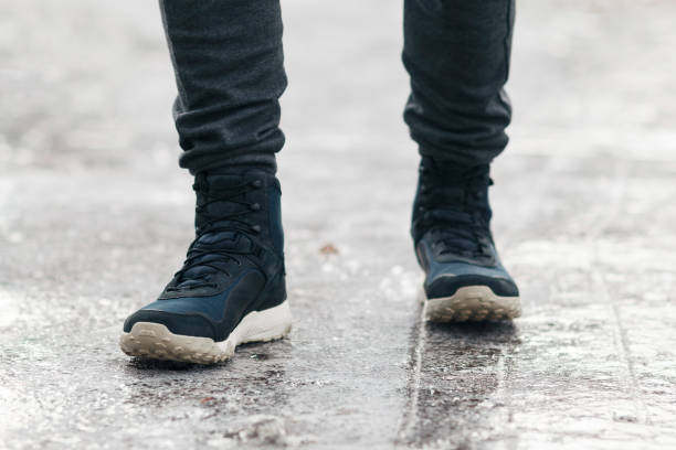 istock People slides on path. Icing on sidewalk, slippery ice-crusted ground 1296988120