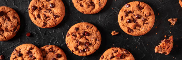 istock Chocolate chip cookies panorama on a black background 1296989203