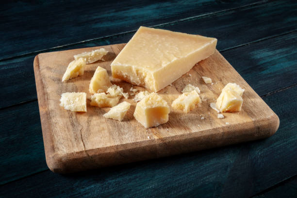 istock Crumbled Parmesan cheese on a wooden cutting board 1296989361