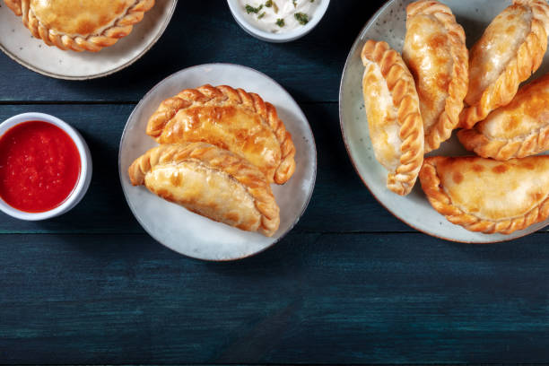 istock Empanadas with sauces, shot from the top with copy space on a dark rustic wooden background 1296989403