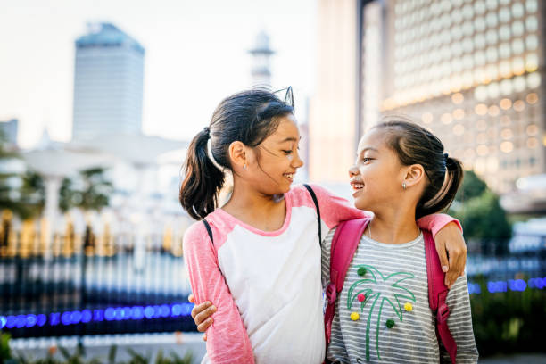 malasia o sureste asan hermanas de diez años de edad que van a la escuela o se divierten - familia con dos hijos fotografías e imágenes de stock