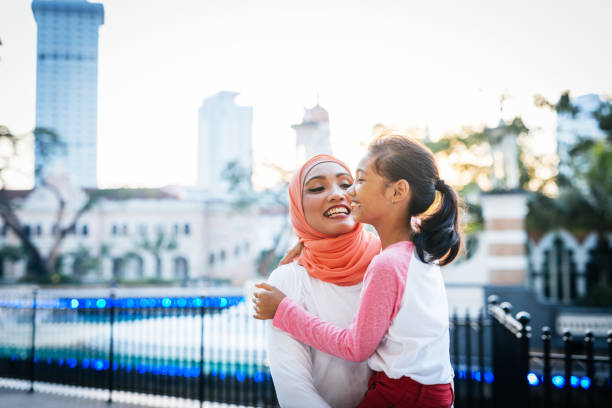 istock Malaysian mother with daughter outdoors, smiling and having fun 1296990759