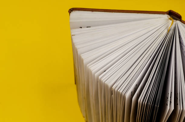 istock Close-up of an Old diary standing on the endpaper against a yellow background. 1296990772