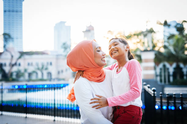 istock Malaysian mother with daughter outdoors, smiling and having fun 1296990845