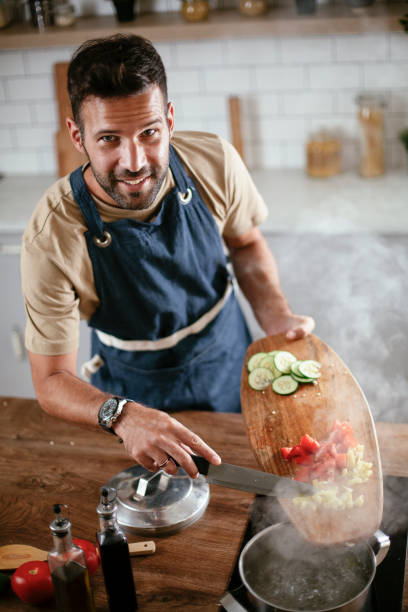 istock Young man cooking lunch at home. 1296992725