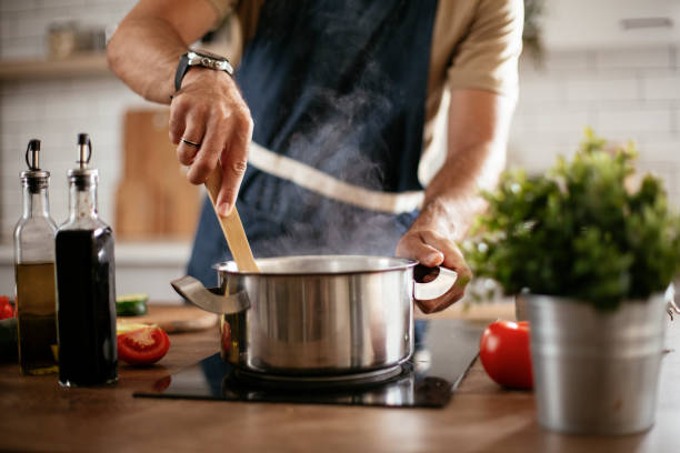 istock Young man cooking lunch at home. 1296992760