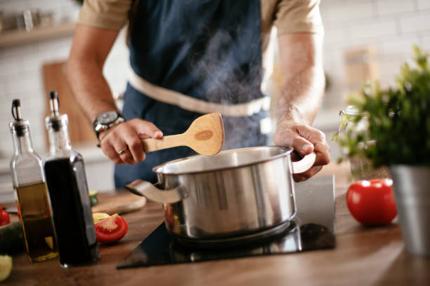 istock Young man cooking lunch at home. 1296993537
