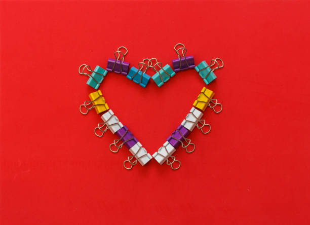 Multicoloured metal office paper clips forming heart shape