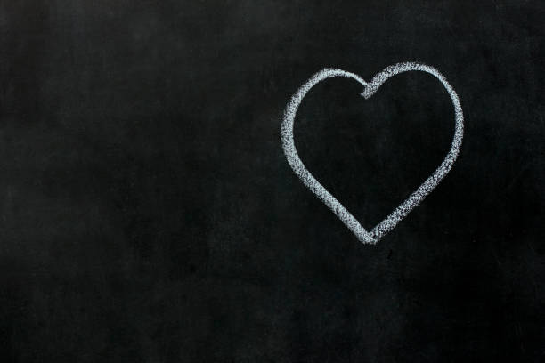 istock White heart drawing chalk on black chalkboard. Concept Valentines day 1296993584