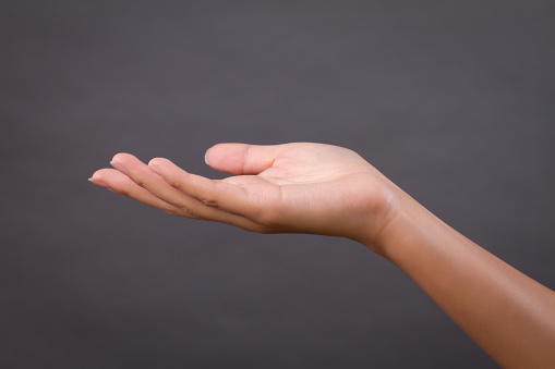 Isolate on white, a young woman's index finger indicates the direction up.