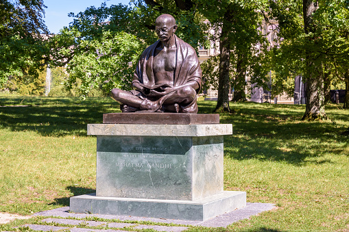 Geneva, Switzerland - September 3, 2020: A statue of Gandhi, offered by the Republic of India to the city of Geneva in 2007 for the first International Day of Non-Violence, in the Ariana park.