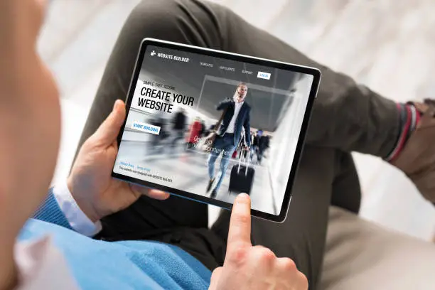 Photo of Man creating website for his business by using tablet
