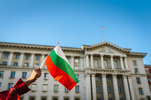 Woman waving the Bulgarian flag in the center of Sofia, Bulgaria. Protest / Patriotism / Human rights concept. Nationalism / Patriotism concept.