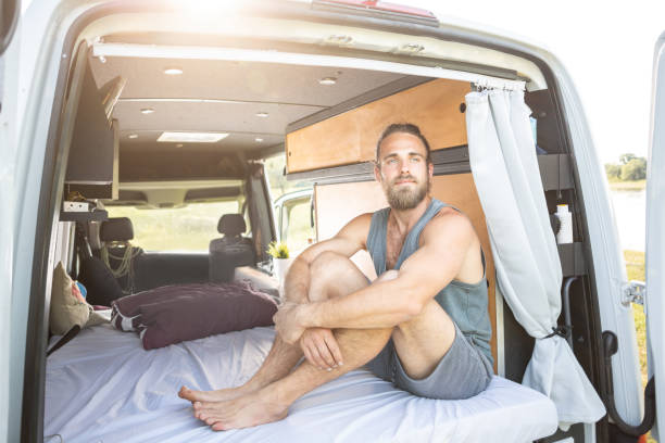istock Young man in the back of his camper van 1297001177