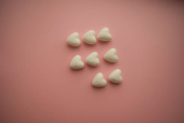 istock Small voluminous white hearts lie on a pink background in three rows and one heart is missing 1297003654