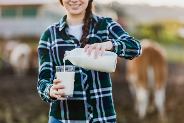 istock Young woman pouring milk into glass 1297005673