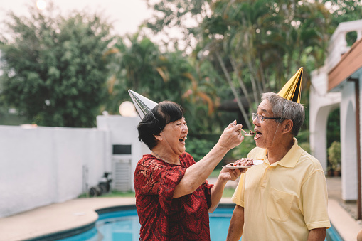 risa asiático china abuela alimentando pastel al abuelo en su celebración de cumpleaños photo