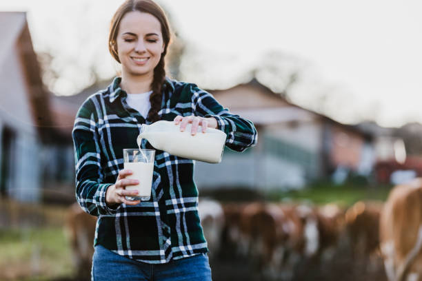 istock Young woman pouring milk into glass 1297005892