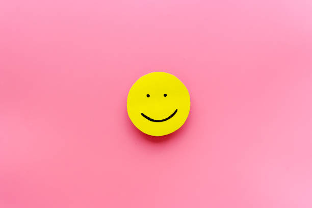 istock Smiling face emotion concept. Smile face on paper banner, top view 1297006696