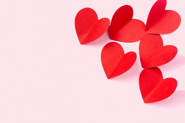 istock Valentine's Day. Paper hearts on a pink background with empty space for your ad. 1297007168