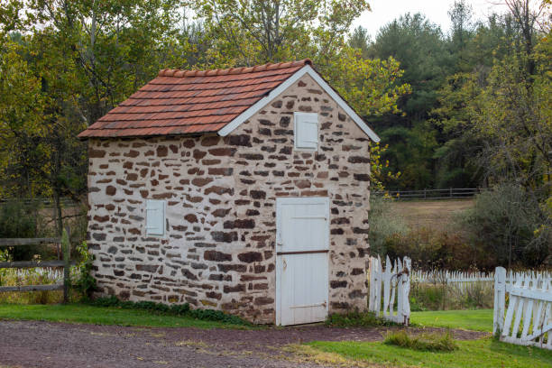 Colonial stone spring house with white door and garden gate.