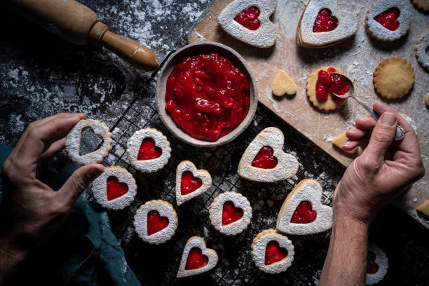 istock Linzer cookies preparation man hands put strawberry jam with spoon 1297008102