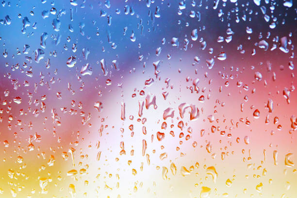 istock rain droplets on glass over calm colorful background. abstract colorful rainy backdrop 1297010211