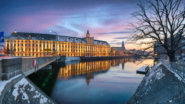 Winter in Wroclaw, Poland. Panoramic cityscape with historic building of University reflecting in Oder river on sunset