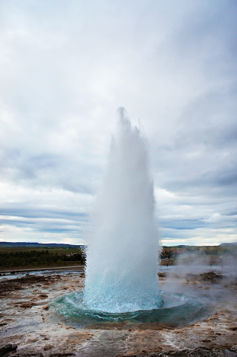 The Great Geysir, geyser in southwestern Iceland, Haukadalur valley, Geyser splashing out of the ground against the background of a cloudy sky, abstract vertical background with water