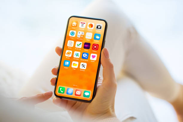 istock Woman using mobile phone with home screen opened showing different everyday app icons 1297013078