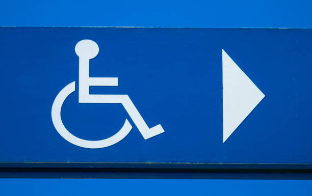 istock Disabled parking sign with direction arrow against blue sky, Close up 1297017396