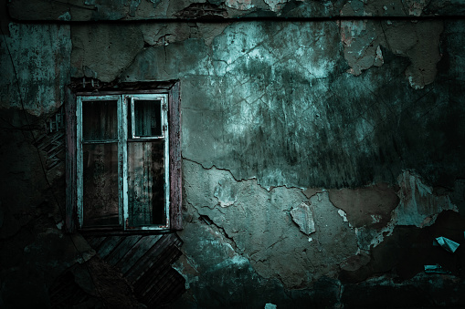 Horror concept background. Scary shabby old texture wall of ruined grunge house and closed window with mystical shadows causing fear