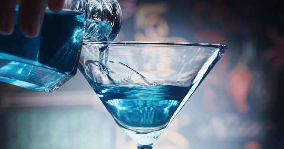 Pouring blue liquid into martini glass