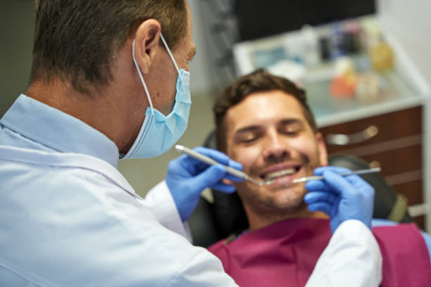 istock Professional dentist examining a young brunette man 1297017877