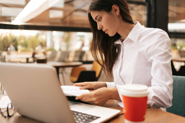 istock Beautiful woman in glasses talking using laptop with smile while sitting and working 1297019281