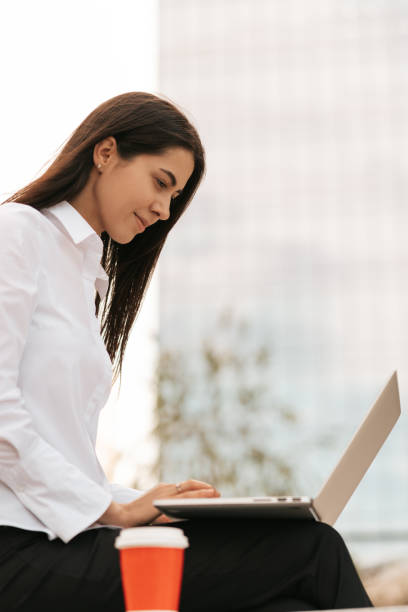 istock Beautiful woman smiling using laptop while sitting and working 1297019453