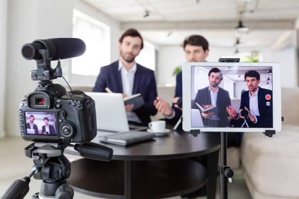 istock Businessmen making a video blog in the office 1297020916