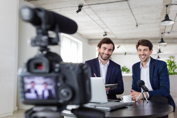 istock Businessmen making a video blog in the office 1297021144