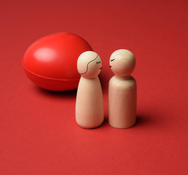 istock two wooden figures on a red heart background 1297023836