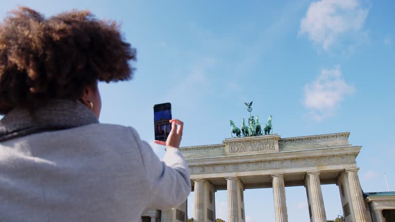 Traveler in Berlin taking photos of Brandenburg gate