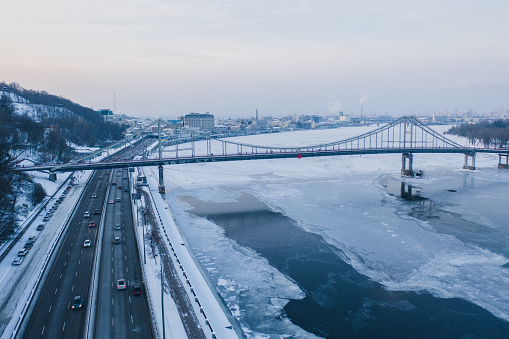 Scenic aerial view of bridge above  frozen river  in Kyiv