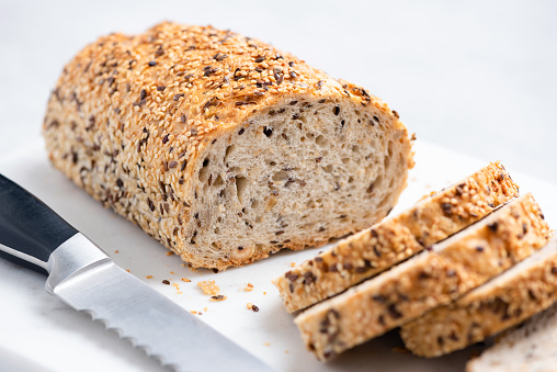 Multigrain wheat bread sliced on marble board. Closeup view. Texture of whole grain bread