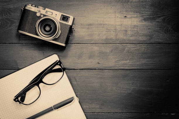 istock Camera, glasses and notepad on wooden background 1297028020