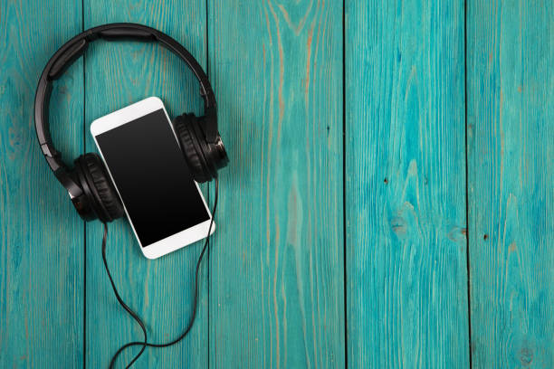 Music online concept - phablet and headphones on the wooden desk
