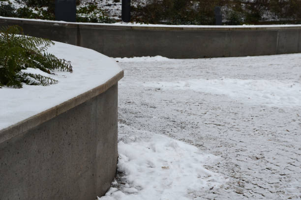 擁壁の近くに雪のベンチ、公園内のコンクリートグレー。冬の19世紀から公園への手すりと壮大な復元された階段 - landscaped retaining wall wall stone ストックフォトと画像