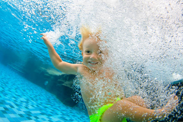 śmieszne małe dziecko nurkować pod wodą - swimming child swimming pool indoors zdjęcia i obrazy z banku zdjęć