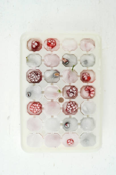 istock Ice cubes with berries. Ice tray with berries on white background. Top view 1297036277