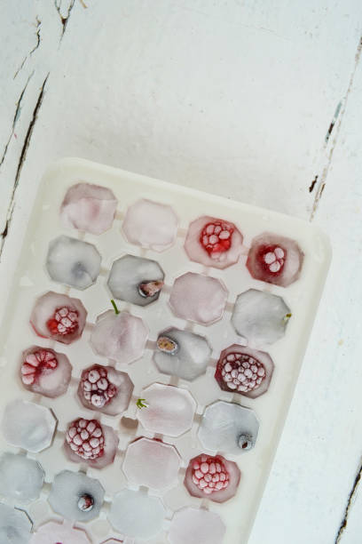 istock Ice cubes with berries. Ice tray with berries on white background. Top view 1297036363